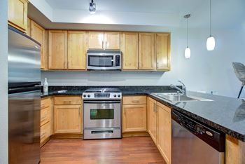 a kitchen with wood cabinets and stainless steel appliances  at 128 on State, Kirkland